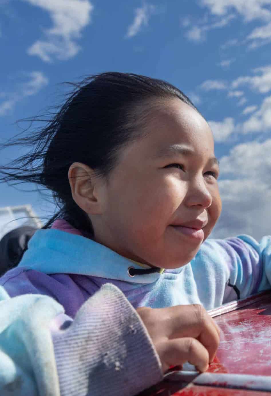 Little kid with wind blowing through her hair on a boat ride